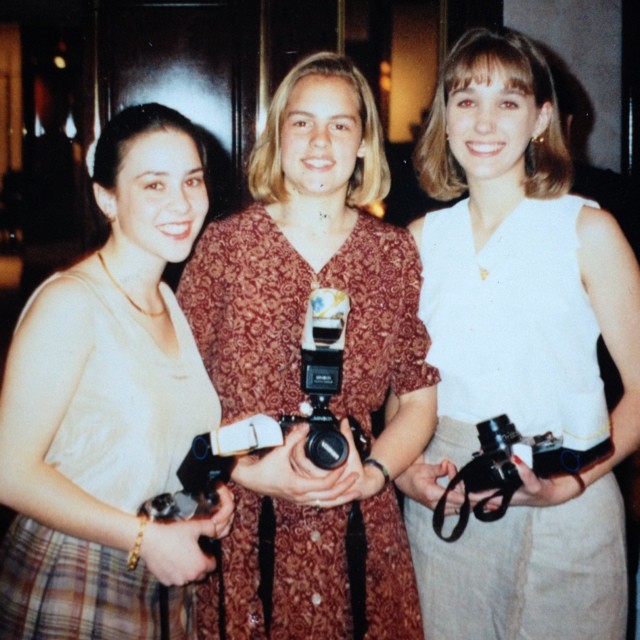 1990s high school girls with analog cameras, like Pentax K1000, dressed up to shoot photos at a senior banquet.