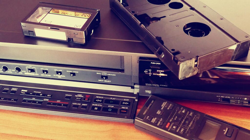 Vintage VHS player with cassette and remote control, representing classic tech nostalgia.