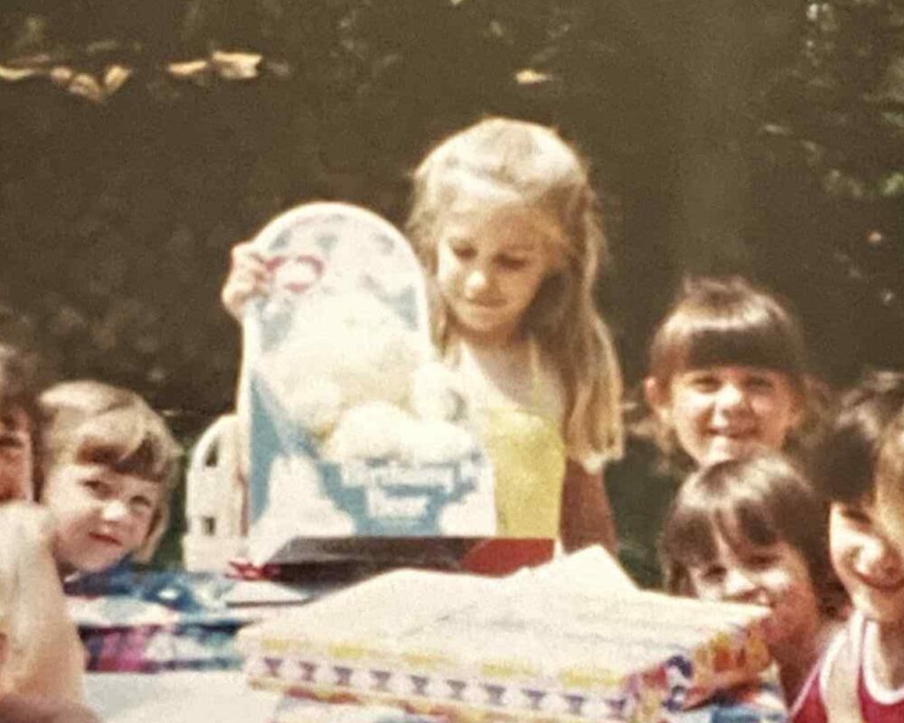 Close-up of girl holding Birthday Bear Care Bear at 1984 birthday party