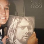 Teenage girl holding a Kurt Cobain book in the early 1990s during the rise of grunge music