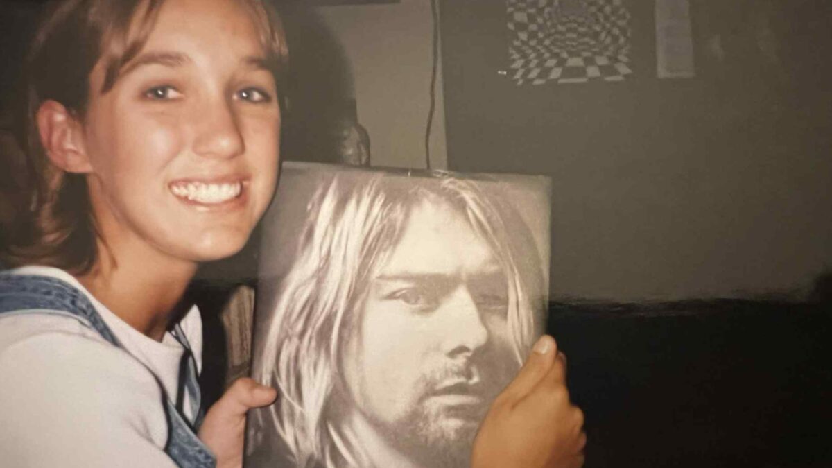 Teenage girl holding a Kurt Cobain book in the early 1990s during the rise of grunge music