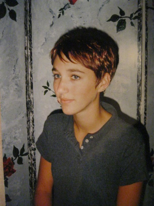 Teen girl with short hair in a candid 1990s-era photo, softly lit against a patterned background